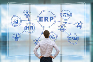 IT manager analyzing the architecture of ERP (Enterprise Resource Planning) system on virtual AR screen with connections between business intelligence (BI), production, HR and CRM modules.